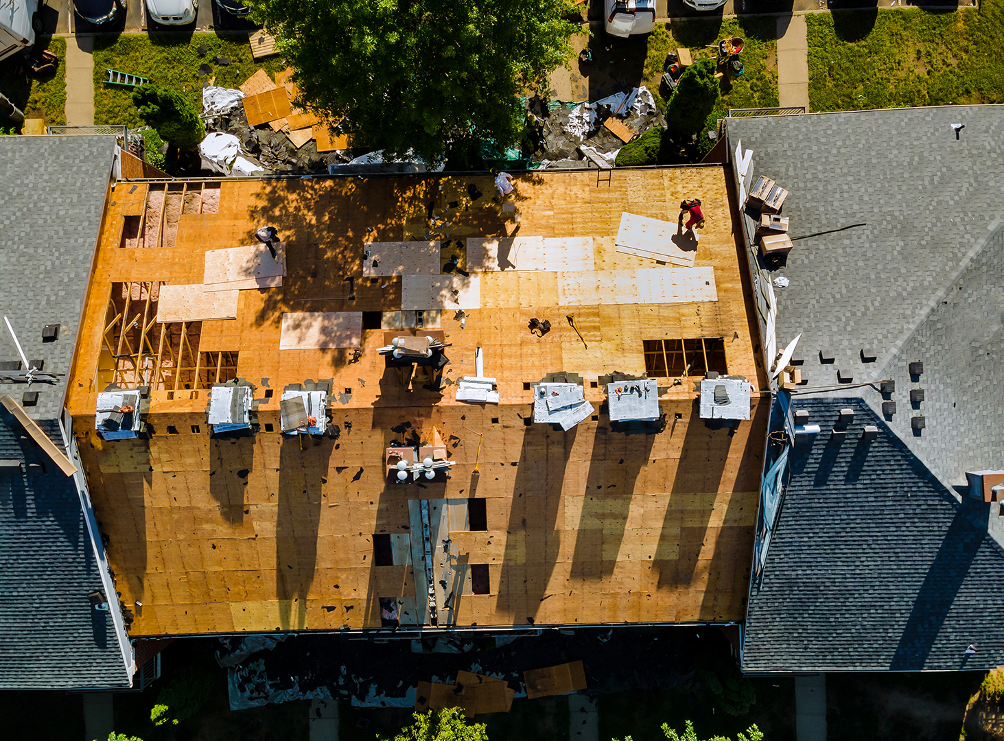 A worker replace shingles on the roof of a home repairing the roof of a home